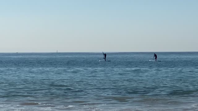mans paddling on a stand up paddle board in front of the coast of Atlantic ocean. Europe.