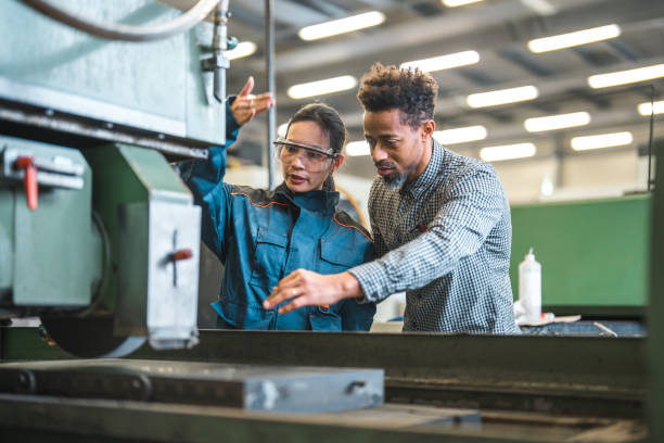 istock Asian Female Blue Collar Worker And Black Male Engineer Collaborating At Work 1468471925