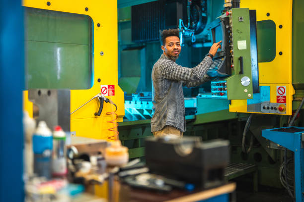 istock Mid Adult Black Male Pressing Control Buttons On A CNC Machine 1468471950