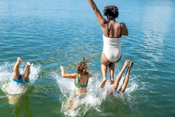amigos buceando en el lago - swimming trunks bikini swimwear red fotografías e imágenes de stock