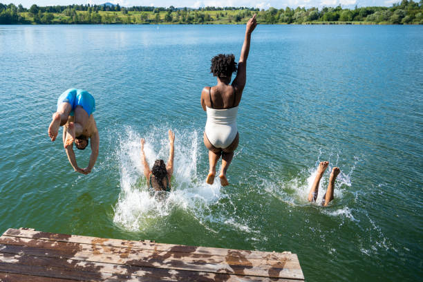 friends diving in lake - swimming shorts shorts swimming trunks clothing imagens e fotografias de stock