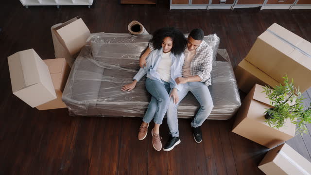 Top view young couple plans housing project, the interior design of new apartment they are moving in