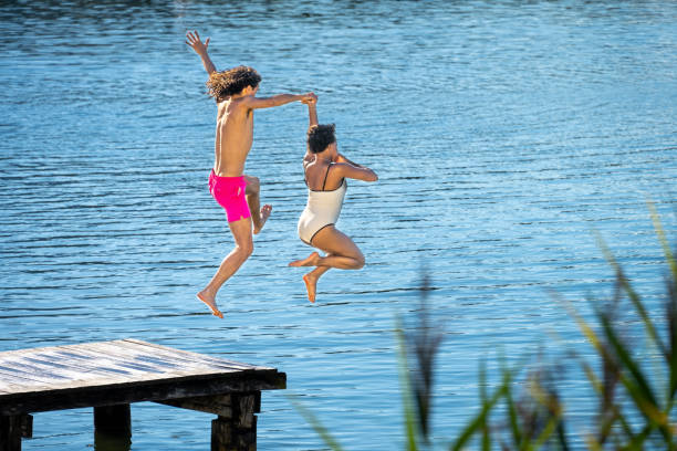 istock Young couple jumping in lake 1468473317