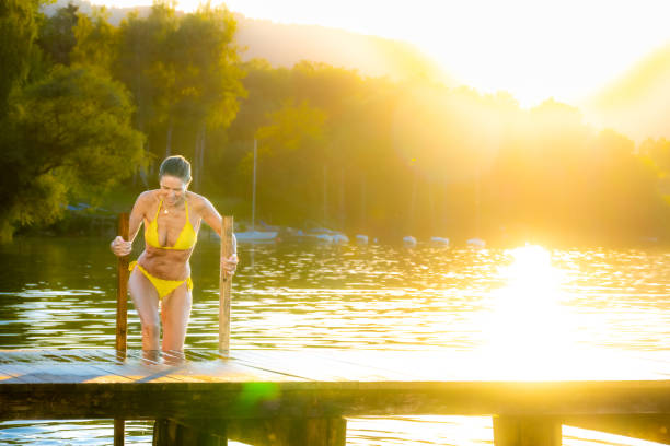 istock Woman in yellow bikini by lake 1468473403