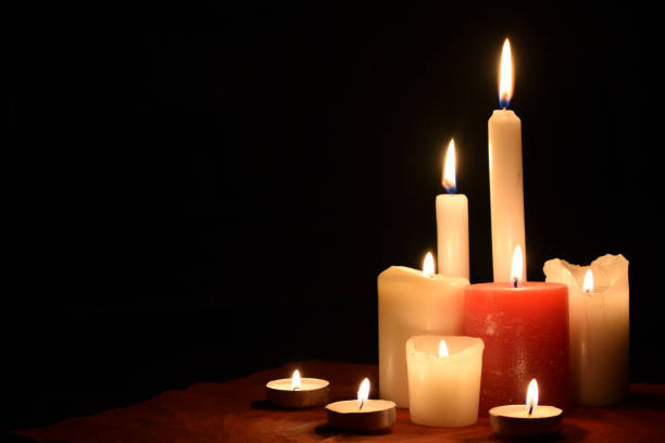 istock Burning candles on table on black background indoors 1468473696