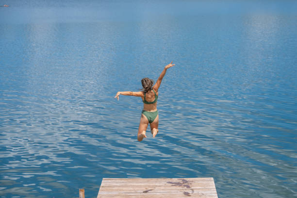istock Woman jumping in lake 1468473745