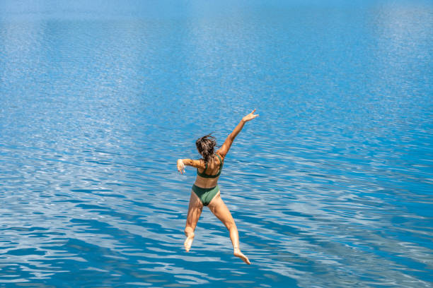 istock Woman jumping in lake 1468473752