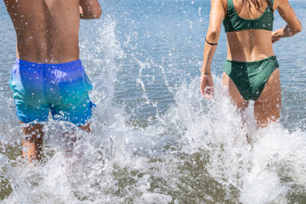 pareja caminando en el lago - swimming trunks bikini swimwear red fotografías e imágenes de stock