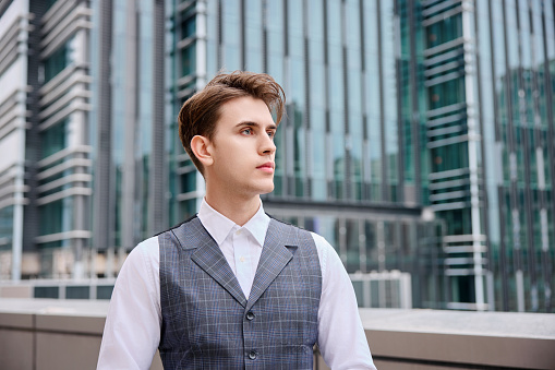 Young businessman against an urban background.