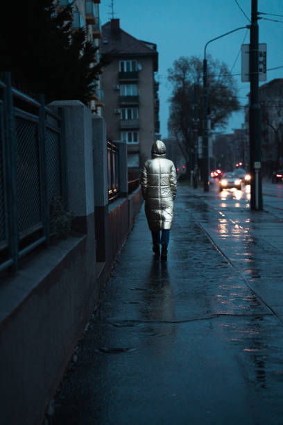 istock Woman walking on a side walk at night 1468477514