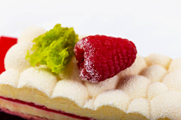 Rows of golden pastries topped with whipped cream and strawberries, individually set in white paper cups.