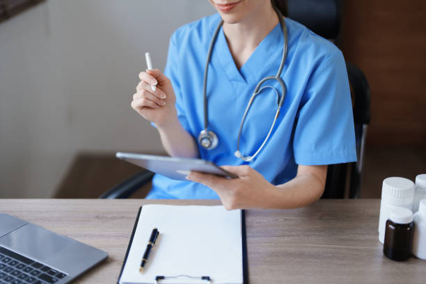 istock Portrait of a female doctor using a tablet computer and a document analyzing a patient's condition before treating. 1468478996