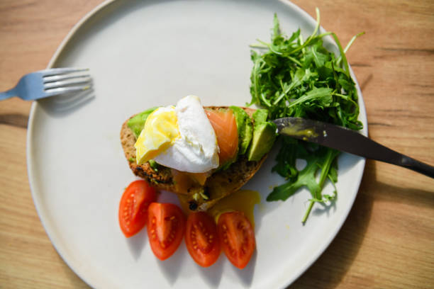 istock Avocado toast with poached egg on a wooden board. 1468485497