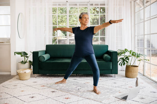 istock Warrior pose for seniors: Mature woman shows her strength and flexibility as she practices this yoga pose at home 1468487825