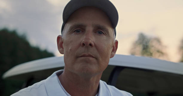 istock Pensive senior golfer standing at golf cart. Old guy looking camera at sunset. 1468490445