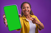 Young happy African American woman demonstrates phone with green display