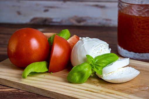 Tomatoes, mozzarella cheese, basil and oil for a fresh appetizer italian style.