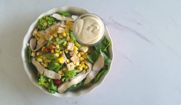 istock Chicken Caesar with green salad on white marble table 1468493501