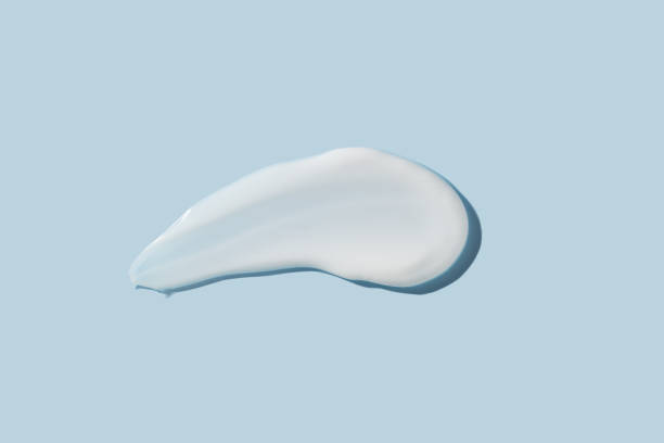 istock Cosmetic product smear white moisturizing lotion isolated on blue, squeezed out and smeared portion of skincare cream product testing. 1468493580