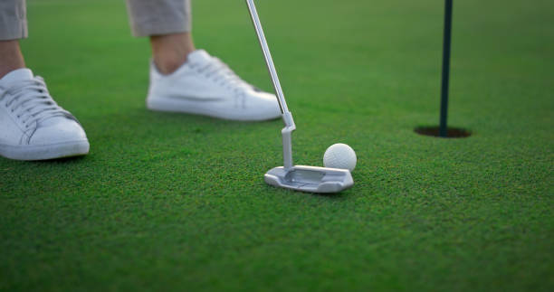 istock Golfer legs hitting ball on green golf course. Sport player teeing score outside 1468496101