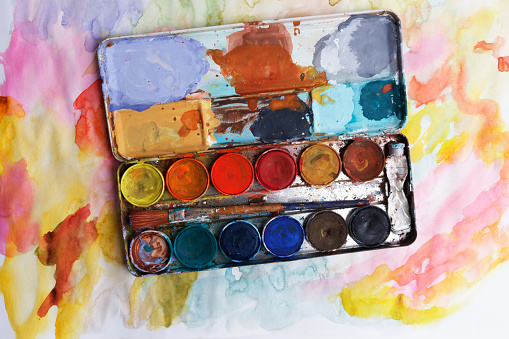 vintage paintbox with old colors inside rusty metal box and with paint brushes