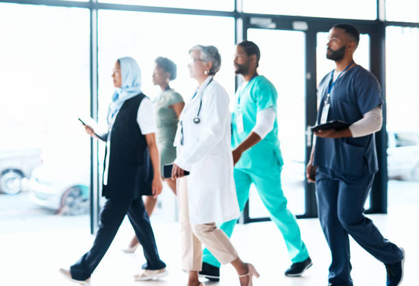 istock Walking, doctor team and hospital employee group ready for teamwork, collaboration and work. Doctors, nurses and adn healthcare workers walk in a wellness clinic lobby with diversity and focus 1468497281