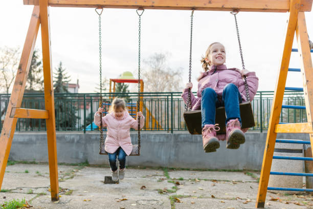 istock Small kids enjoying on a swing at the playground 1468497429