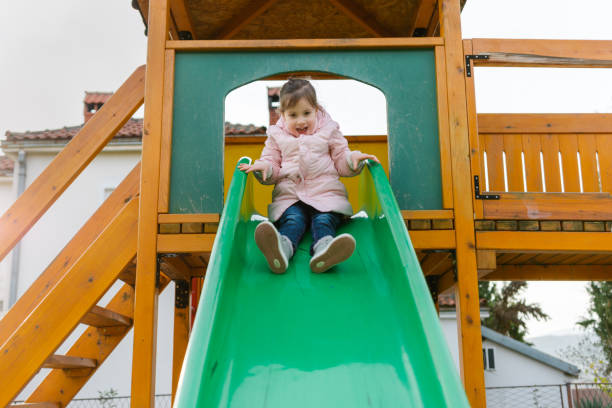 istock Cute little girl having fun while sliding at playground 1468497498