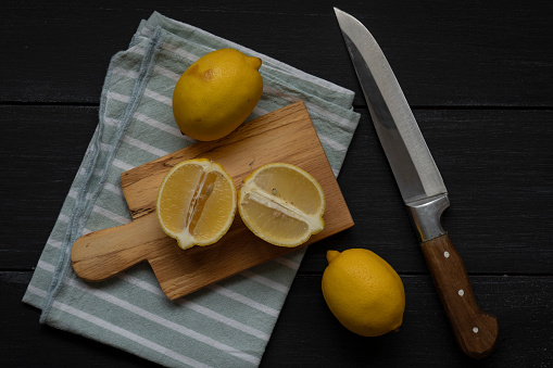 Lemons on cutting board on a wooden table