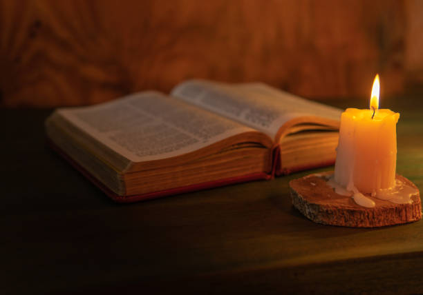 istock Selective focus of a candle lighting up on a bible. Religious message concept 1468499977