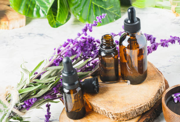 istock Essential oil containers on cut wooden log with lavender flowers 1468500062
