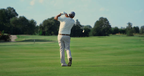 Old man play golf on grass fairway. Pro player swing club hitting ball outside. Old man play golf on green grass fairway. Pro player swing club hitting ball outside. Focused golfer making shot at golfing country club. Rich senior enjoy active retirement. Sport weekend concept. golfer swinging club stock pictures, royalty-free photos & images