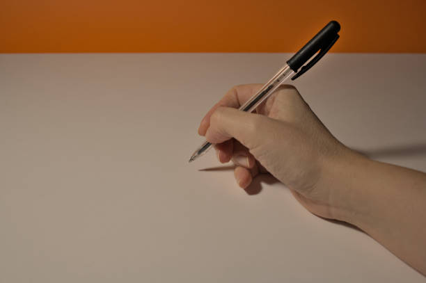 istock Woman's hand with pen writing on white paper 1468501728