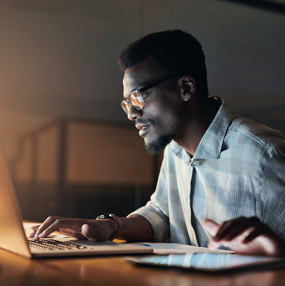 Businessman, thinking or laptop typing in night office on financial management, insurance budget or company investment. Black man, employee or working late on technology, finance growth or idea goals