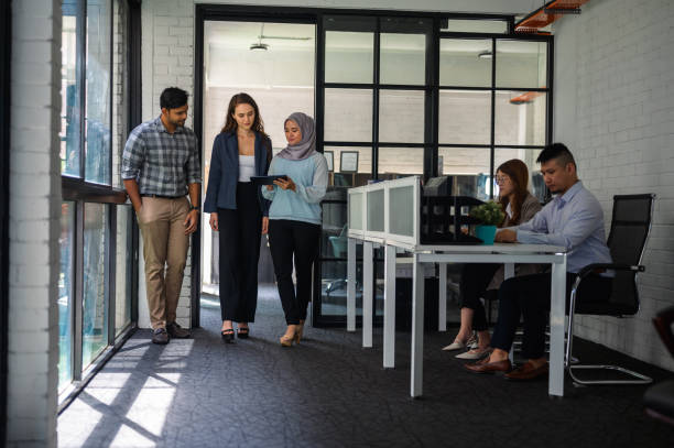 istock Business people walking through corridor and talking 1468503410