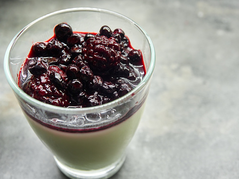 Dessert panna cotta in glass with sirup of berries