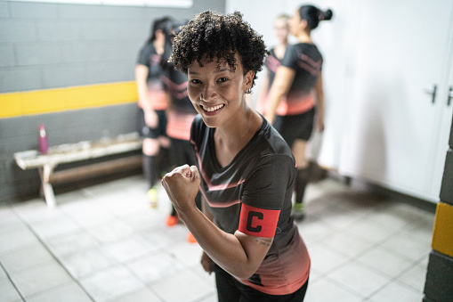 Portrait of a female soccer player celebrating in the locker room