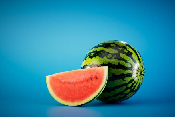 istock a large round watermelon next to a slice of watermelon on a blue background. 3D render 1468511466
