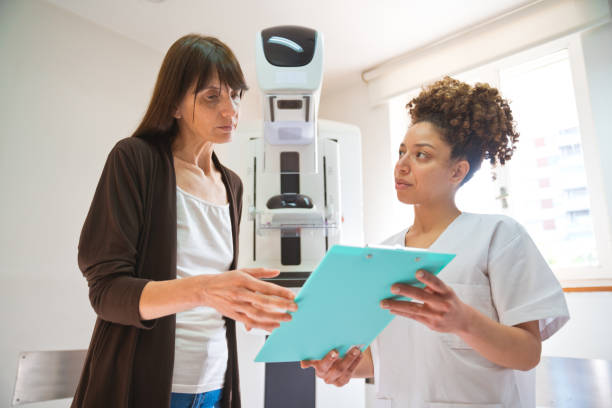 young nurse talking with female patient - x ray image radiologist examining using voice imagens e fotografias de stock