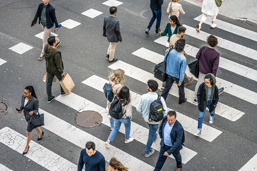 High angle view of business people crossing street on zebra crossing in city.