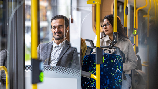 Mature businessman and woman sitting in bus.
