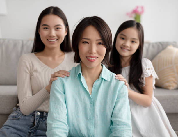 大人の娘とかわいい孫娘が家でポーズをとる成熟したアジア人女性、選択フォーカス - grandmother granddaughter senior adult teenager ストックフォトと画像