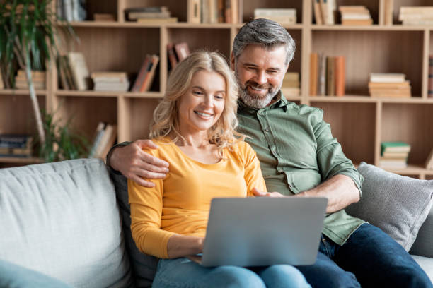 istock Smiling Middle Aged Spouses Resting With Laptop In Living Room Interior 1468516634