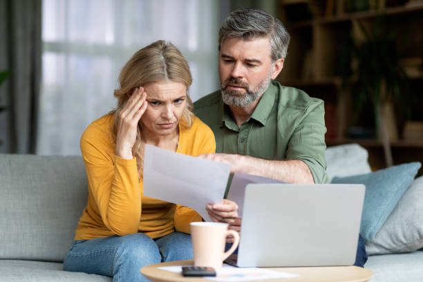 istock Stressed Middle Aged Spouses Checking Financial Papers At Home 1468516955