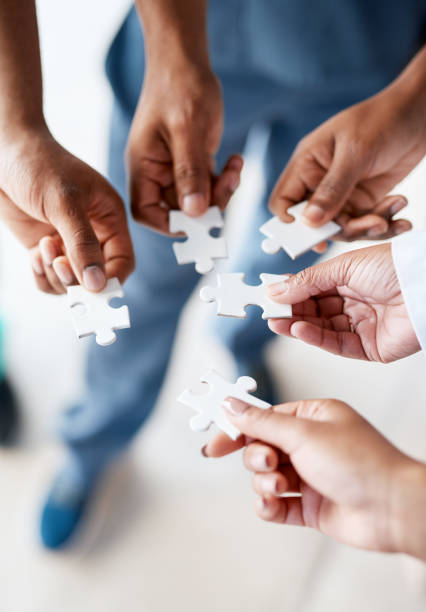 Hands, puzzle pieces and business, planning or teamwork on project in office with group collaboration. Cooperation, support team and people with jigsaw for innovation, solution and problem solving. stock photo