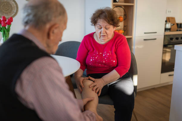 istock Elderly woman getting assistance  from her husband when having a knee pain issues 1468521841