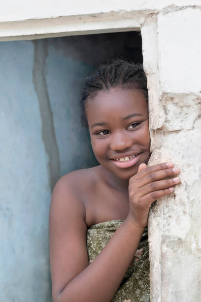 young afro girl standing at the door of her house, smiling expression, photo - africa south africa child african culture imagens e fotografias de stock