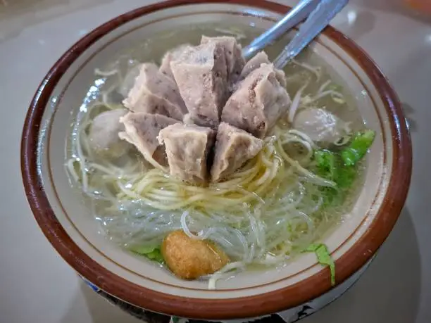 Indonesian Street Food , Bakso - Meatball , super big tendon meatballs with noodles, vermicelli, tofu and assorted green vegetables in a delicious beef broth served in a warm bowl