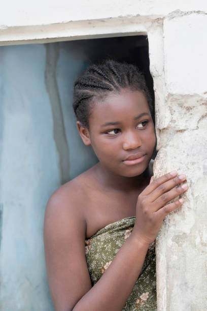 young afro girl at the door of her house, serious expression, 12 years old, photo - africa south africa child african culture imagens e fotografias de stock