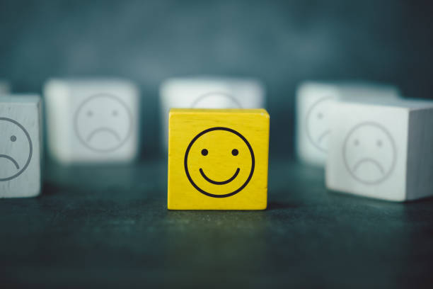 istock One wooden cube blocks with emotions and thoughts a clearly smiling face with a sad face of wood block blurred in the back. 1468527306